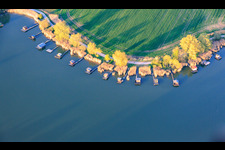 Des promenades en bois bordées de cabanes de pêcheurs longent les rives de l'étang du Welschhof. à Puttelange-aux-Lacs dans le département Moselle, France