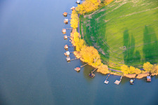 Des promenades en bois bordées de cabanes de pêcheurs longent les rives de l'étang du Welschhof. à Puttelange-aux-Lacs dans le département Moselle, France