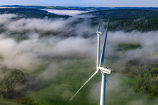 Les rotors du parc éolien Fürstenau dépassent des nuages bas à le quartier Fürstenau in Höxter dans le département Rhénanie du Nord-Westphalie, Allemagne hors des airs